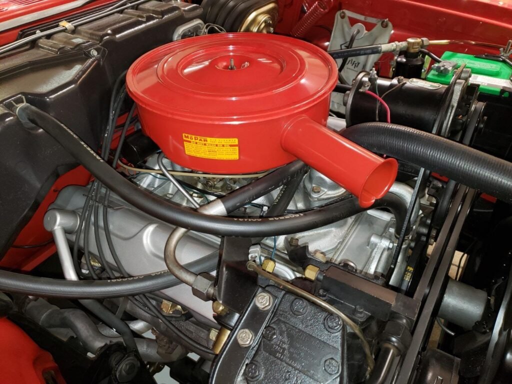 A vibrant 1960 Dodge Dart Phoenix Convertible gleams under soft lighting. Its bold fins, chrome trim, and open-top design scream classic American style.